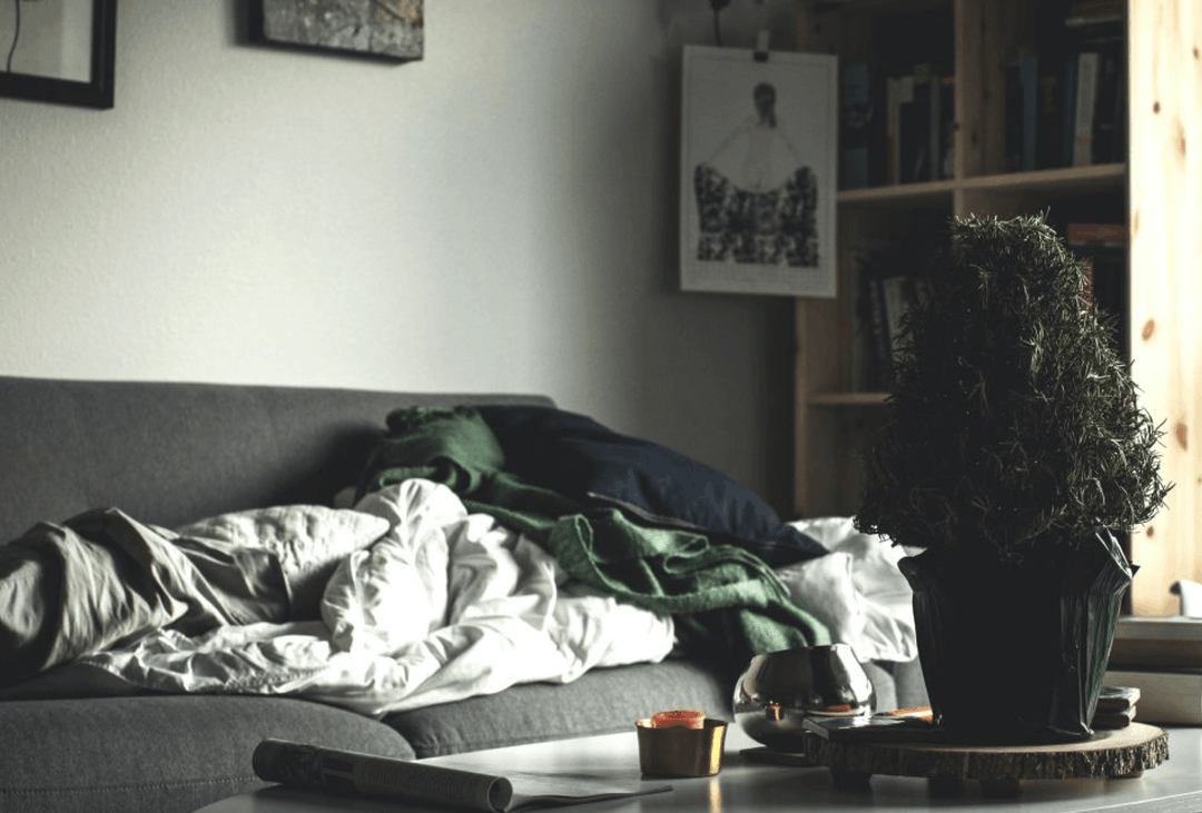 Empty sofa with rumpled blankets in a quiet home with no one present
