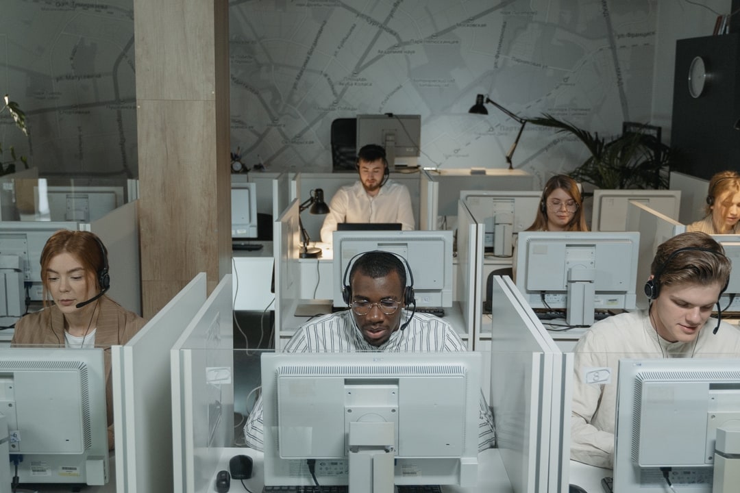Employees working at assigned desks and workstations on an office floor